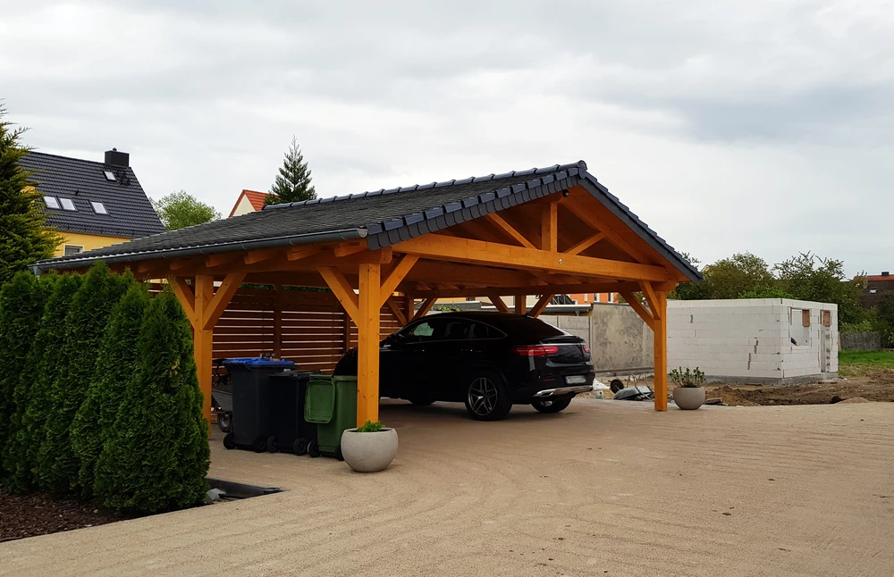 Scène extérieure résidentielle avec carport en bois abritant une voiture noire