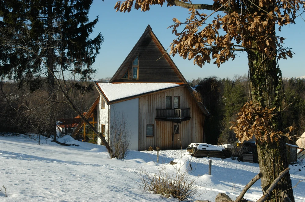 Paysage hivernal extérieur avec bâtiment agricole traditionnel à toit triangulaire en bardeaux bois