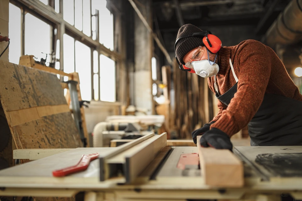 Ouvrier en bâtiment consulte des plans sur chantier de construction à ossature bois
