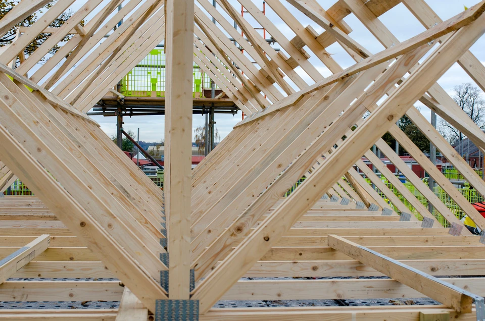 Un homme en chemise bleue effectue des travaux de peinture sur une terrasse couverte résidentielle
